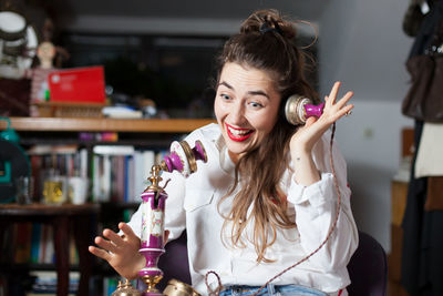 Smiling woman talking on telephone at home