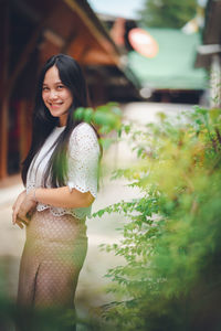 Portrait of a smiling young woman standing outdoors