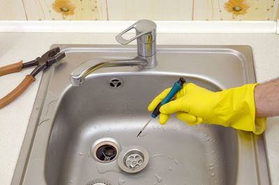 Cropped hand repairing sink