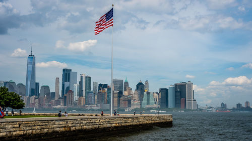 Flag on modern buildings in city against sky