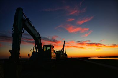 Low angle view of silhouette crane against sky during sunset