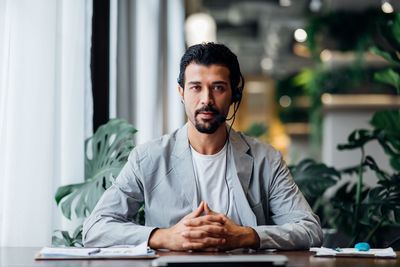 Portrait of young man sitting on table