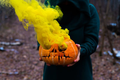 Midsection of man holding pumpkin