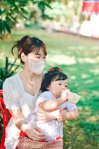 Side view of young woman blowing bubbles in park