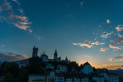 Buildings in city against sky during sunset