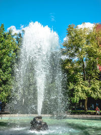 Water splashing in fountain against sky