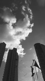 Low angle view of skyscrapers against cloudy sky