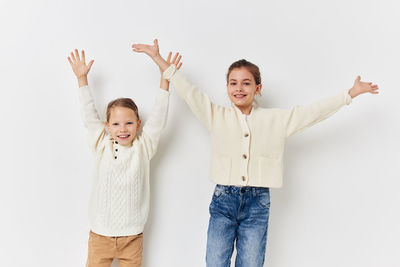 Happy sisters against white background