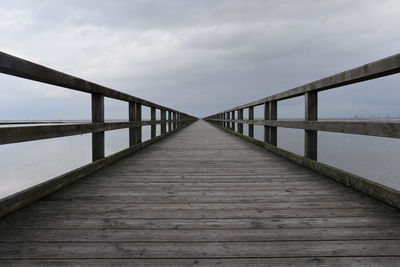 Footbridge over water against sky