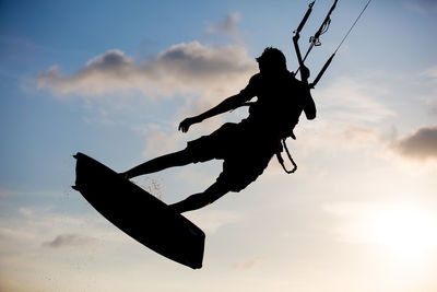 Silhouette kite surfer against the sky