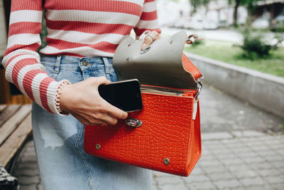 Midsection of woman holding bag