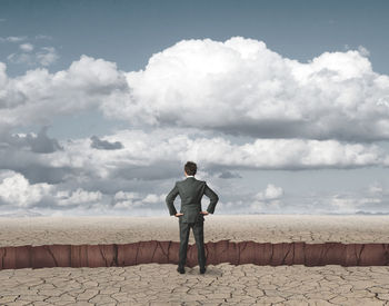 Rear view of man standing on street against sky