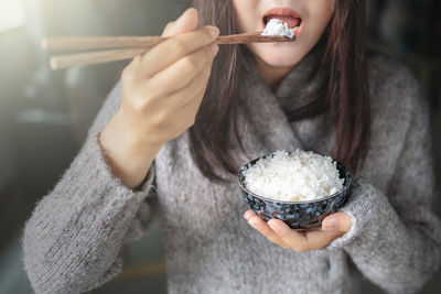 Midsection of woman eating ice cream