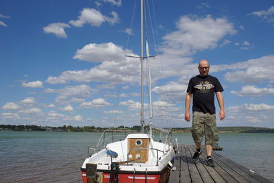 Full length of man standing on sea against sky