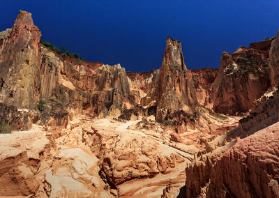 Rock formations on mountain against blue sky