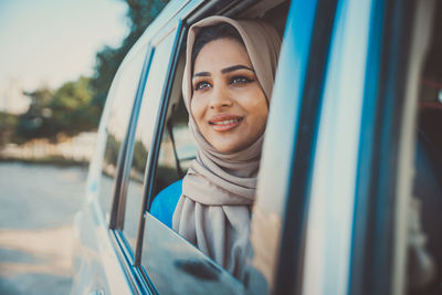 Portrait of smiling young woman in car