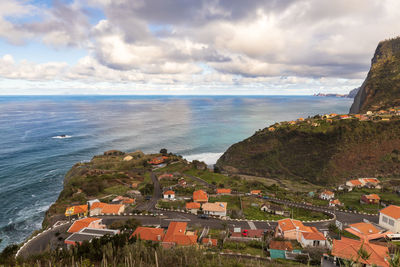 High angle view of townscape by sea against sky