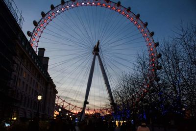 Low angle view of ferris wheel at dusk