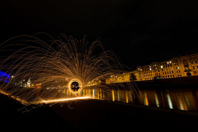 Illuminated bridge over river at night