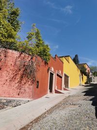 Street amidst houses and buildings against sky
