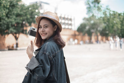 Portrait of smiling young woman standing outdoors