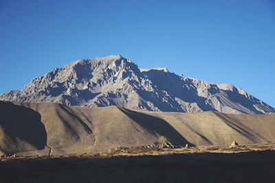 Scenic view of snowcapped mountains against clear blue sky
