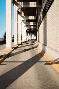 Empty road amidst buildings during sunny day