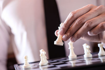 Midsection of businessman playing chess