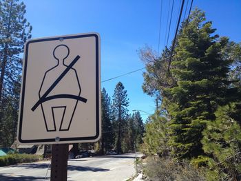 Close-up of road sign against clear blue sky