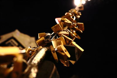 Close-up of padlocks on metal against black background