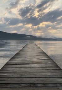 Pier over sea against sky during sunset