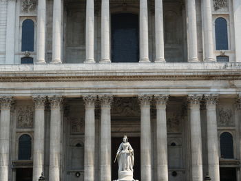 Low angle view of statue of queen anne gainst pillars of st paul's cathedral in london