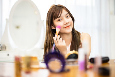 Portrait of young woman holding camera