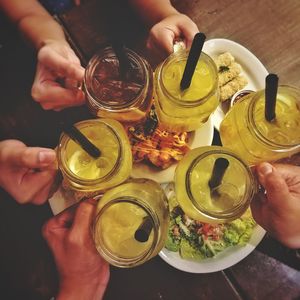 High angle view of people holding drink on table