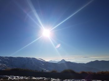 Scenic view of mountains against blue sky