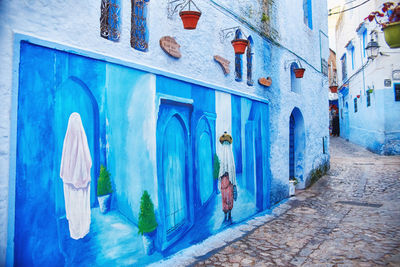 People in alley amidst buildings in city