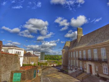 Buildings against cloudy sky