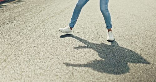 Low section of woman walking on road