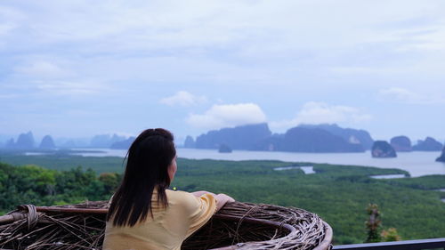 Rear view of woman looking at mountain against sky