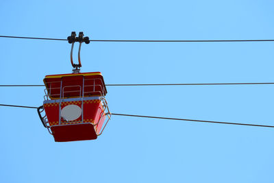 Low angle view of overhead cable car against blue sky