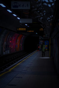 Rear view of person on illuminated railroad station platform
