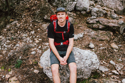Portrait of man sitting on rock