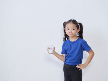 Portrait of girl standing against white background