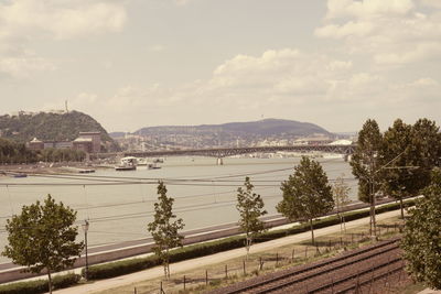 High angle view of city by river against sky