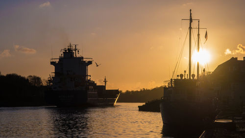 Silhouette of sailboats in sea against sky during sunset