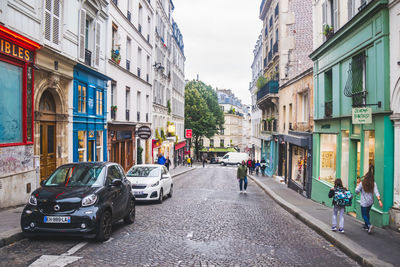 People on street amidst buildings in city
