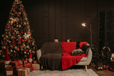 Rear view of woman sitting on sofa at home