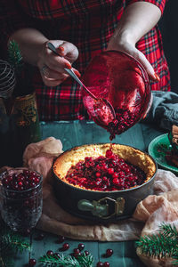 Traditional homemade french cake with cranberries served on green wooden table.