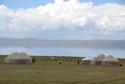 View of temple on field against cloudy sky