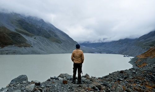 Rear view of woman standing on snowcapped mountain